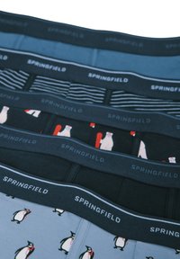 Quattro paia di boxer con elastico. I modelli includono pinguini e orsi, in tonalità blu e nere con design a righe e solidi.