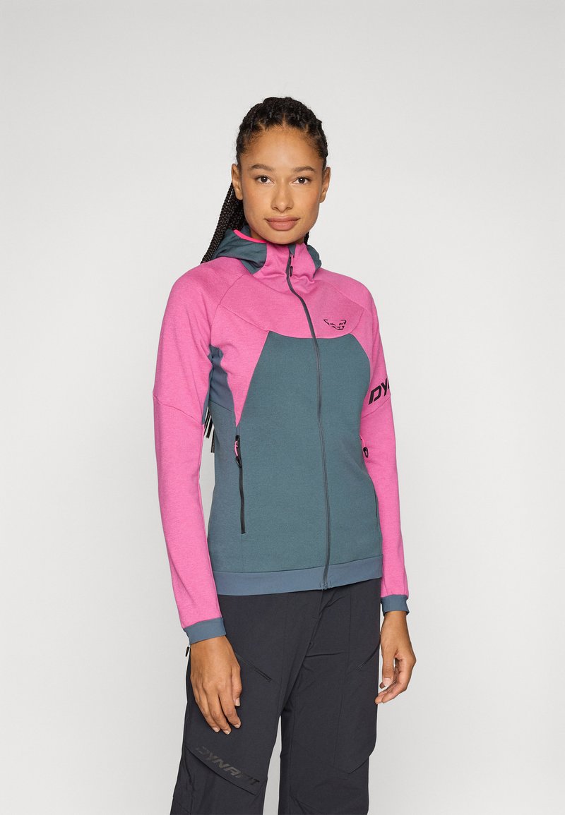 Giacca in pile con zip, caratterizzata da una sezione superiore rosa e una sezione inferiore teal. Include cappuccio, tasche e polsini e orlo a contrasto.