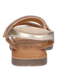 Bruine leren flip-flop sandaal met metallic accenten, voorzien van meerdere banden en een gestructureerde voetbed. Platte zool met lichte doorzichtigheid.