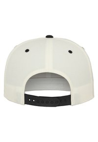 Cappellino da baseball bianco con una fascia nera regolabile. Presenta una visiera curva e un bottone nero sulla parte superiore. Tessuto con texture liscia.