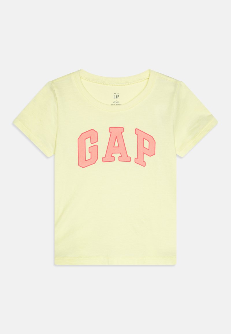Gul bomulls T-skjorte med korte ermer, med en stor rosa "GAP"-logo i store bokstaver over fronten. Glatt tekstur, rund utrigning.