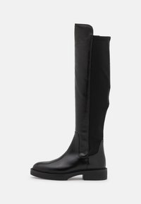 Botas negras hasta la rodilla que combinan cuero liso y tela, con una suela gruesa y un diseño minimalista.