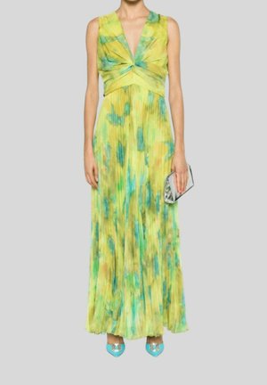 Abito maxi plissettato in giallo e verde con scollo a V profondo e corpetto attorcigliato. Abbinato a una borsa a tracolla argento e scarpe con tacco alte blu.