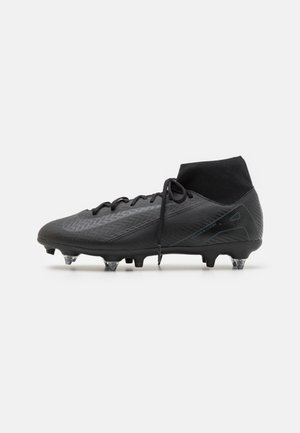 Schwarzer knöchelhoher Fußballschuh mit Schnürsenkeln, strukturiertem Obermaterial und genopptem Absatz, entwickelt für festen Untergrund.