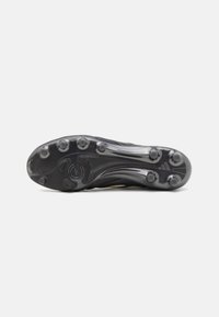 Black soccer cleat featuring a textured upper, molded studs on a translucent outsole, and subtle yellow accents along the sides.