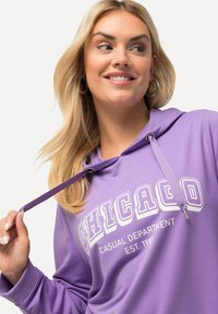 Felpa viola con cappuccio regolabile, grande scritta "CHICAGO" in bianco e vestibilità casual. Tessuto liscio con polsini a costine.