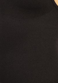 Bodysuit negro de tejido acanalado con una textura suave. Presenta un escote redondeado y un diseño ajustado, que enfatiza la comodidad y la flexibilidad.