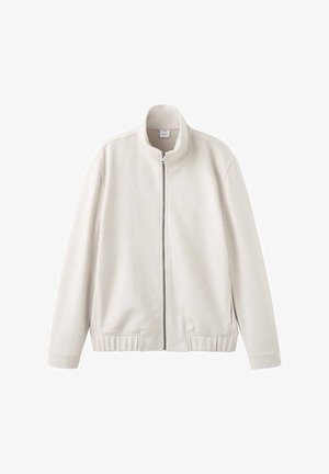 Giacca beige chiaro con zip, collo alto, polsini e orlo a coste. Tessuto morbido con una texture liscia e senza motivi o accenti visibili.