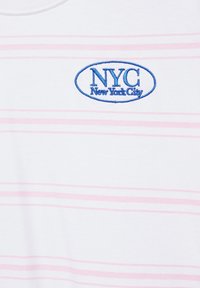 Tissu blanc avec de fines rayures horizontales roses et un texte brodé en bleu indiquant "NYC New York City" à l'intérieur d'un ovale.
