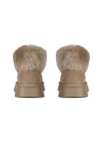 Botas de tobillo marrones con un forro de pelaje suave y un exterior de ante, que cuentan con una suela de goma plana y una construcción sin costuras.