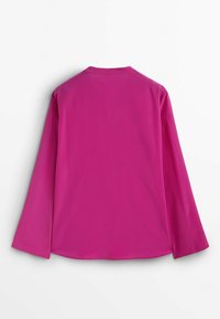 Blouse à manches longues en rose vif, texture lisse, décolleté rond, avec un léger drapé. Design épuré, sans motifs ni éléments visibles.