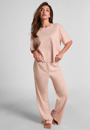 Roze loungewear set met een T-shirt met korte mouwen en een borstzakje, en losse broek. Soepele textuur, comfortabele pasvorm en zachte stof.