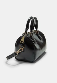 Borsa a mano in pelle nera dalla forma arrotondata, con due manici, dettagli in metallo dorato e tracolla staccabile; finitura Texturizzata e chiusura con zip.