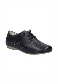 Scarpa in pelle nera con design floreale intagliato, punta rotonda e chiusura con lacci. Presenta una suola in gomma beige e una texture liscia.