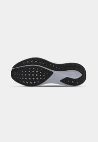 Semelle de chaussure avec une bande de roulement en caoutchouc noir et une semelle intermédiaire blanche, présentant un motif texturé pour l’adhérence et un petit logo swoosh près du talon.