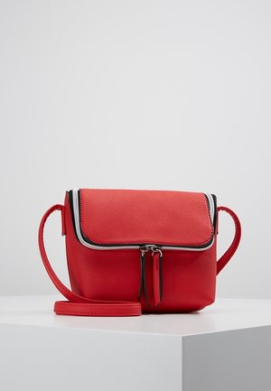 Czerwona torebka na ramię z podwójnym zamkiem błyskawicznym, prostokątną klapką i regulowanym paskiem, prezentowana na białym postumencie na szarym tle.