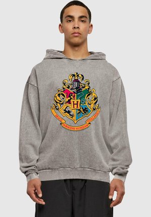 Felpa con cappuccio grigia caratterizzata da un colorato stemma ricamato di Hogwarts con vari simboli, contornato in giallo e con un banner sottostante.
