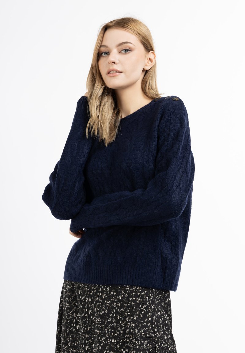 Pulover tricotat de culoare bleumarin, cu un model texturat, mâneci largi și o margine ribonată, având un detaliu cu nasture pe umăr.