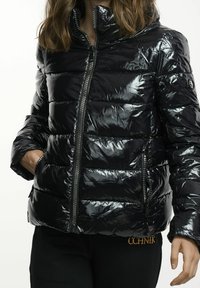 Czarna kurtka puchowa z błyszczącą, pikowaną tkaniną, wysokim kołnierzem, suwakiem z przodu i bocznymi kieszeniami; wyróżnia się eleganckim, nowoczesnym designem.