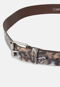 Cintura in pelle marrone e decorata con una fibbia in metallo argentato, caratterizzata da una superficie testurizzata e un logo decorativo sulla cinghia.