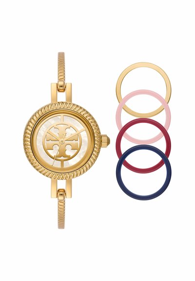 Guld rund armbandsklocka med dekorativ urtavla och texturerat band, visas med fyra utbytbara boetter i guld, rosa, rött och mörkblått.