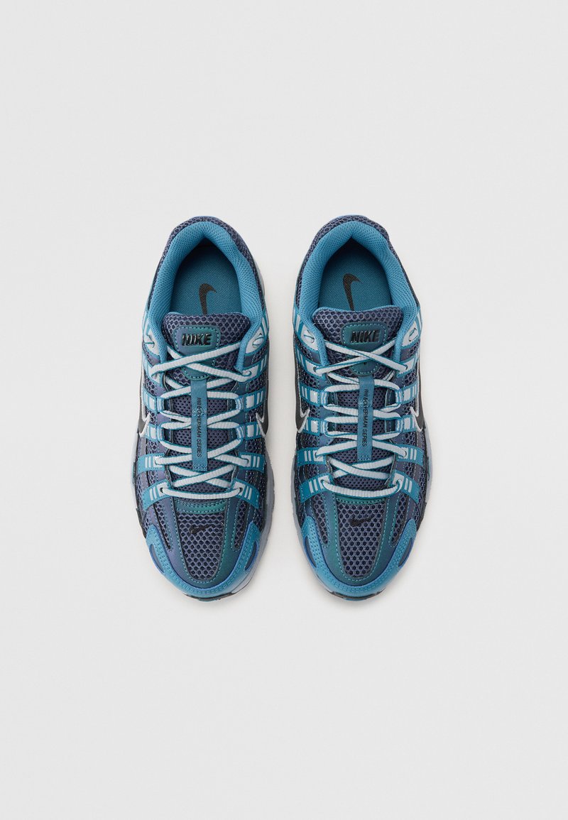 Nike-Sneaker in Blau und Dunkelblau. Obermaterial aus Mesh mit textile Überzügen. Schnürsenkel und Akzente in Hellblau. Schwarzes Logo an der Zunge. Gekrümmte Sohle.