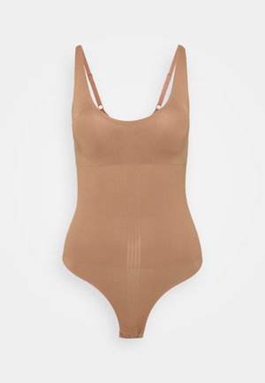 Nahé tielko vyrobené z hladkého, pružného materiálu s výstrihom do tvaru lode, tenkými nastaviteľnými ramienkami a strihom do tanga na spodnej časti.