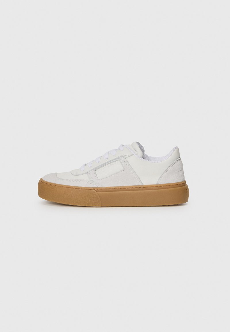 Λευκό αθλητικό παπούτσι με σουέτ λεπτομέρειες, στρογγυλή μύτη, σχέδιο με κορδόνια και σόλα από καουτσούκ γόμας. Υφή στην επάνω επιφάνεια. Μινιμαλιστικό στυλ.