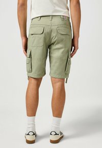 Grüne Baumwoll-Cargo-Shorts mit mehreren Seitentaschen, geradem Schnitt und sicherem Sitz an der Taille. Verfügt über verstärkte Nähte.