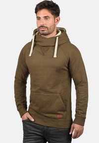 Olivengrøn hoodie med høj krave, cremefarvede snore, kænguru-lomme og en struktureret overflade. Har en lille labeldetalje.