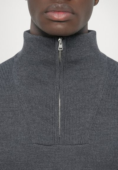 Camisola cinza canelada com gola alta e meio fecho de correr. Tecido texturizado e linhas limpas, destacando o detalhe do fecho de correr.