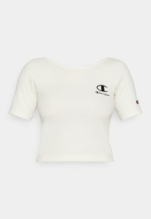 Gekürztes, cremefarbenes T-Shirt aus geripptem Stoff. Mit einem schwarzen Champion-Logo auf der linken Brust und einem kleinen Logo auf dem Ärmel.