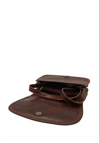 Sac en cuir marron à bandoulière avec une texture lisse. Design ouvert avec des poches intérieures et un système de fermeture à pression magnétique. Longue bandoulière réglable.