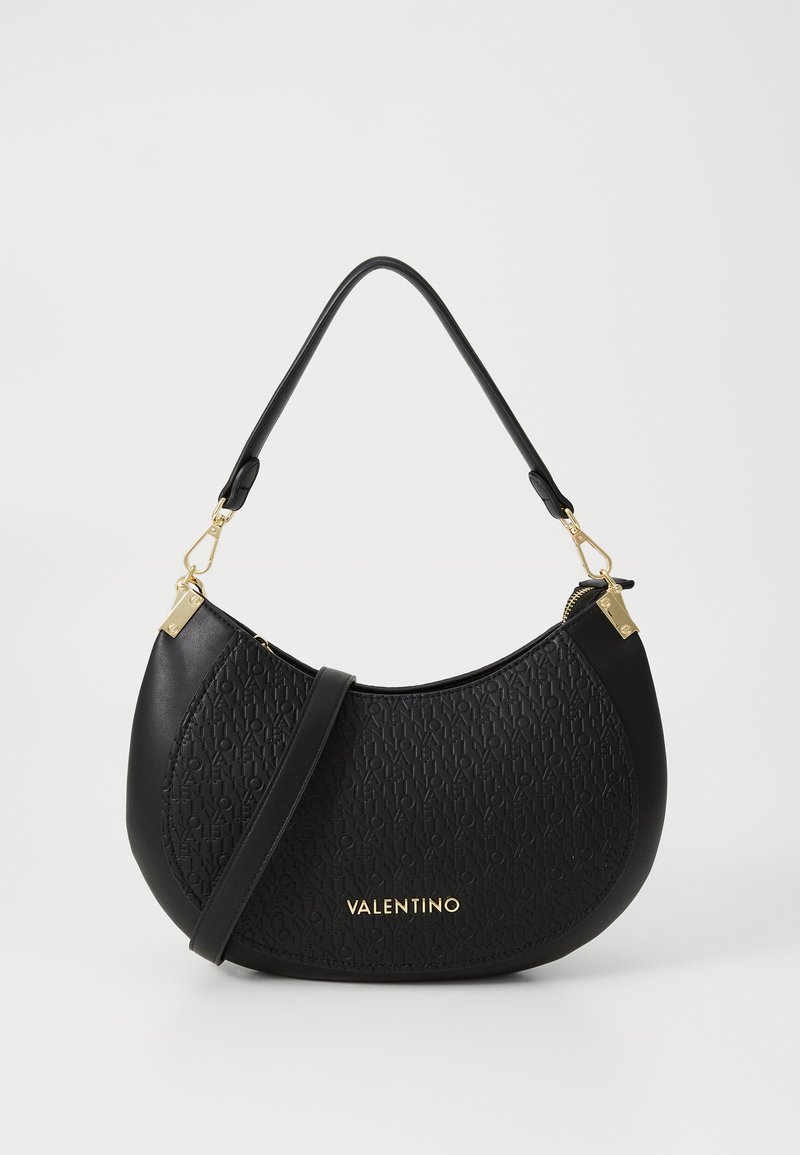 Μαύρη δερμάτινη τσάντα με υφασμάτινη επιφάνεια, καμπυλωτό σχήμα, χρυσές ραφές και ιμάντα ώμου. Διαθέτει λογότυπο στο μπροστινό μέρος.