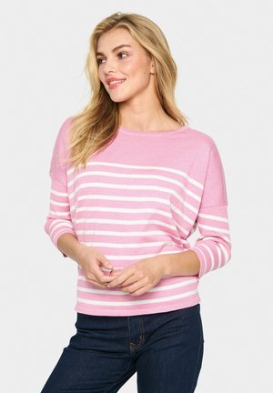 Pull en rose clair fabriqué dans un matériau tricoté doux, avec des rayures blanches horizontales, un large décolleté et des manches trois-quarts.