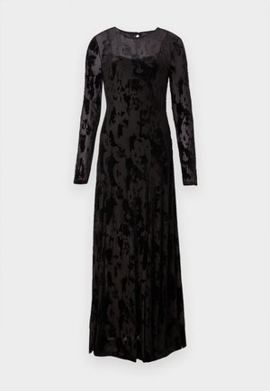 Duga crna haljina od teksturiranog materijala, s dugim rukavima, kvadratnim izrezom i lepršavom siluetom s mekanim nabranim detaljima.