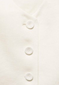 White, textured fabric with a V-neckline and three round buttons down the front. The buttons have a simple, flat design.
