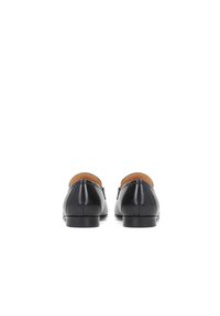 Černé kožené boty s hladkým povrchem, nízkým podpatkem a kulatou špičkou. Design zahrnuje slip-on styl s kontrastním hnědým vnitřkem.