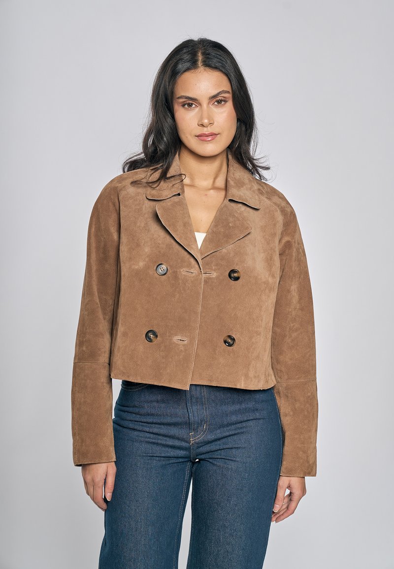 Giacca corta in camoscio marrone con davanti doppiopetto, revers a incavo e due bottoni. Texture liscia e vestibilità sartoriale.