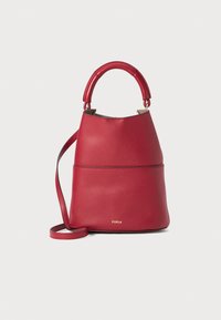 Sac à main en cuir rouge, de forme seau structurée, avec une courte anse et une bandoulière longue et ajustable. Détail du logo en or visible.