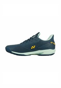 Scarpe sportive da uomo di colore blu navy realizzate in rete leggera con un motivo testurizzato. Presentano una punta rinforzata, un logo giallo a contrasto e una suola bianca.