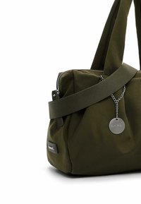 Olijfgroen stoffen draagtas met een ritssluiting, zijklep en zilverkleurige hardware. Voorzien van een afneembare schouderriem en een ronde hanger.