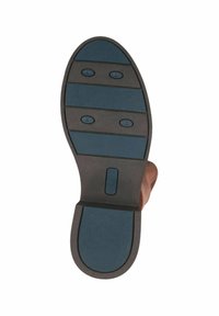 Semelle de chaussure marron avec caoutchouc texturé bleu. Comprend quatre sections de prise surélevées et une forme arrondie distincte. Bord lisse avec détail de logo.