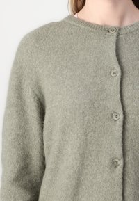 Gray wool cardigan featuring a rounded neckline and five-button closure, with a soft texture and relaxed fit.