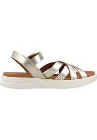 Sandalias plateadas metálicas con tiras entrecruzadas, plantilla marrón y suela blanca. Correa ajustable en el talón para un ajuste seguro.