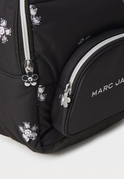 Zwarte stoffen rugzak met wit bloemmotief, zilverkleurige ritsen en ritsen met bloemenvormige trektouwtjes. Voorzien van het Marc Jacobs-logo in zilver.