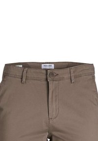 Pantalon décontracté marron avec fermeture par bouton et passants pour ceinture, montrant la partie avant supérieure et une étiquette à l'intérieur de la ceinture.