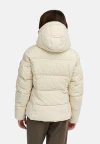 Veste à capuche en duvet de couleur blanc cassé, avec un design matelassé et des poignets élastiques. Fini sans coutures et ourlet légèrement court.