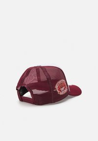 Μπορντό και άσπρο καπέλο με δίχτυ στην πλάτη, που διαθέτει κεντημένη ετικέτα που αναφέρει το έτος 1933 και ένα λογότυπο. Μαλακό γείσο με υφή.