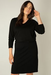 Zwart jurkje met V-hals en driekwart mouwen, gemaakt van een gladde stof, met een getailleerde pasvorm en een knielengte.